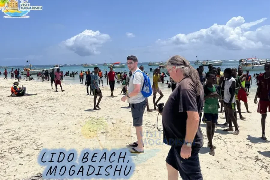 Tourist walking at Lido Beach with locals in Mogadishu, Somalia